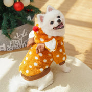 Small white dog wearing an orange Christmas Reindeer Pet Costume with a Christmas tree in the background