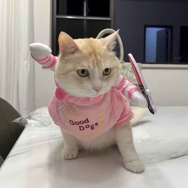 Cat wearing a pink Cute Halloween Costume with 'Good Dogs' text and white socks on a bed.
