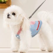 White dog wearing Cute Pet Overalls Dress Denim and Plaid Style a blue and red checkered harness on a light background