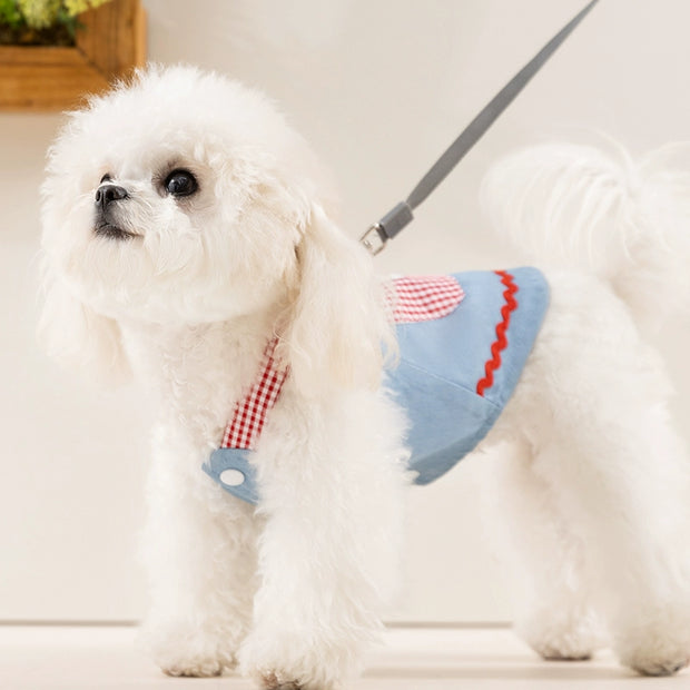 White dog wearing Cute Pet Overalls Dress Denim and Plaid Style a blue and red checkered harness on a light background