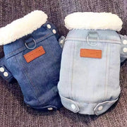 Two Denim Dog Jacket with white fur lining on a textured surface.