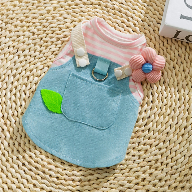 Cute Pet Overalls Dress Denim and Plaid Style, pink striped shirt, and flower accessory on a woven surface