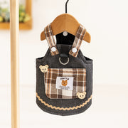 Cute Pet Overalls Dress Denim and Plaid Style suspenders and bear decorations hanging on a wooden hanger.