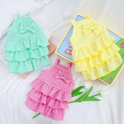 Three colorful Ruffle Layered Dress on a white background with a toy box.