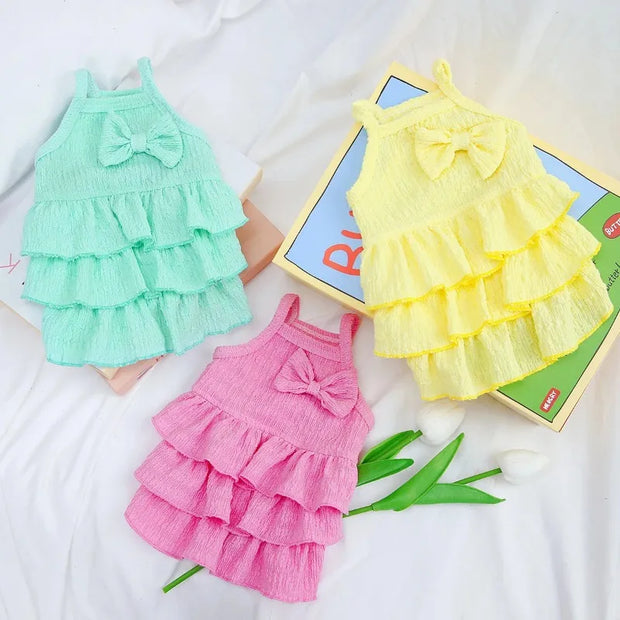 Three colorful Ruffle Layered Dress on a white background with a toy box.