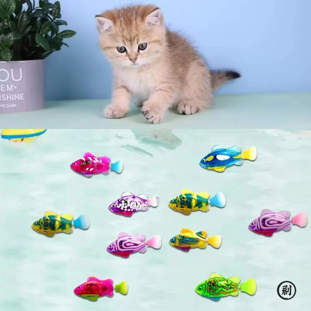 Kitten with colorful Interactive Electric Swimming Fish Toys on a light green surface