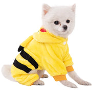 Small white dog wearing a yellow Dinosaur Hoodie Costume with black stripes on a white background