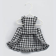 Black and white Checkered Pet Dress with Matching Bib on a hanger against a light gray background