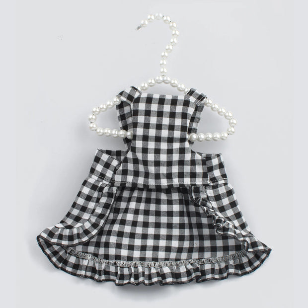 Black and white Checkered Pet Dress with Matching Bib on a hanger against a light gray background