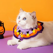 Cat wearing a Halloween Knitted Collar with a purple and orange design on a purple surface with an orange background.