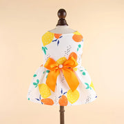 Summer Princess Dress with lemon pattern and orange bow on a mannequin against a beige background
