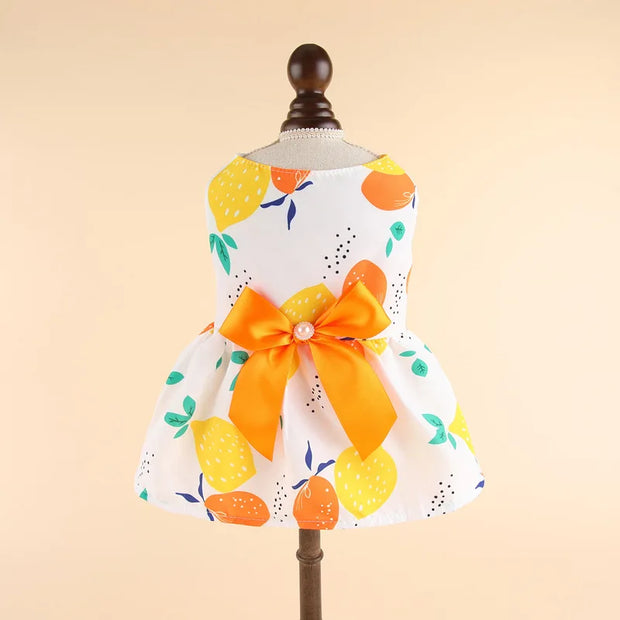Summer Princess Dress with lemon pattern and orange bow on a mannequin against a beige background