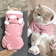 Cat in a pink Dinosaur Hoodie Costume with white accents on a wooden floor.