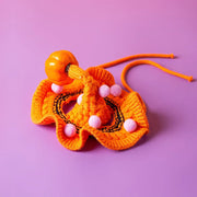 Orange Pet Halloween Knitted Collar with pink pom-poms on a purple background