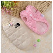 Pink Winter Dog Jacket on a textured surface with decorative elements.