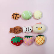 Set of colorful Soft Plush Pet Sports Balls Toy Set shaped like a fish, a strawberry, and a pineapple on a pink background.
