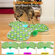 Cat playing with a green Hide and Seek Interactive Cat Toy Blanket on a wooden floor, with text about operation modes.