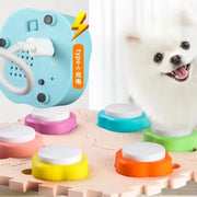 Colorful Pet Training Button electronic device with charging cable and a small white dog on a wooden floor.