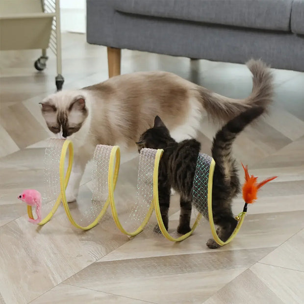 Two cats playing with a yellow Interactive Spiral Cat Toy Spring Tunnel with Plush Mouse on a wooden floor.