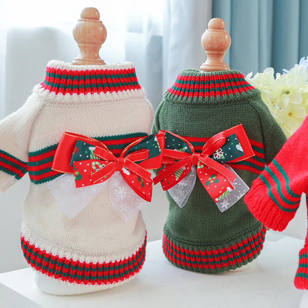 Two Christmas Dog Sweater with red bows on a white surface.