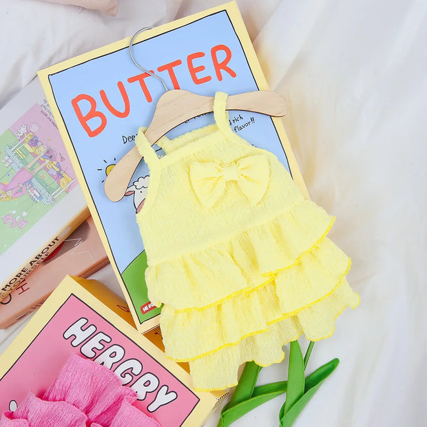 Yellow Ruffle Layered Dress on a hanger with 'BUTTER' and 'HERCZY' books in the background.