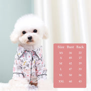 White dog wearing a floral Elegant Pet Shirt with a size chart on a light background
