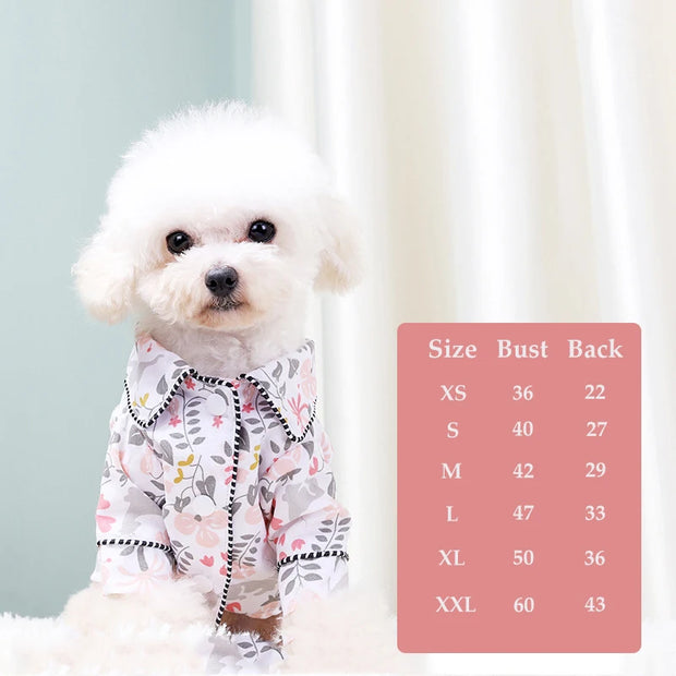 White dog wearing a floral Elegant Pet Shirt with a size chart on a light background