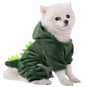 Small white dog wearing a green Dinosaur Hoodie Costume on a white background