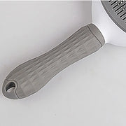 Side view of gray Pet Grooming Brush with One Click Hair Removal placed on soft surface