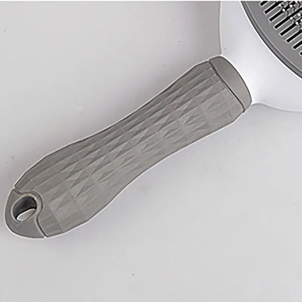 Side view of gray Pet Grooming Brush with One Click Hair Removal placed on soft surface