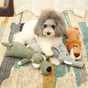 Dog sitting on a patterned rug with stuffed Plush Animal Dog Toys