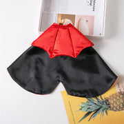 Black and red Vampire Cape Costume on a white surface with books and a pineapple illustration.