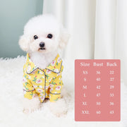 White dog wearing a yellow floral Elegant Pet Shirt with a size chart on a white background