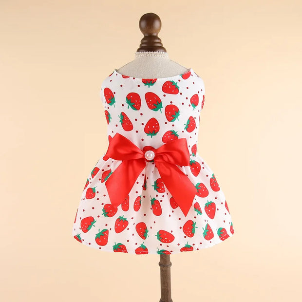 Summer Princess Dress with strawberry pattern and red bow on a mannequin against a beige background