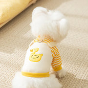 Small white dog wearing a yellow and white striped Duck Overalls Pet Outfit on a beige surface.