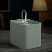 Green Modern Pet Water Fountain  with a handle on a dark surface
