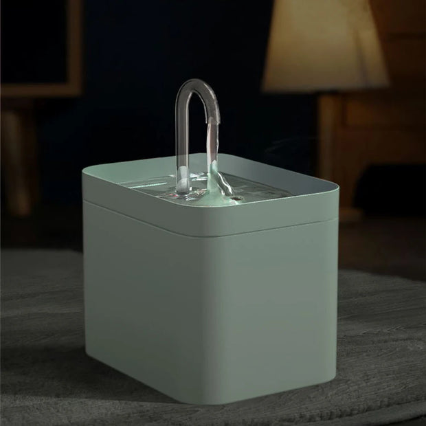 Green Modern Pet Water Fountain  with a handle on a dark surface