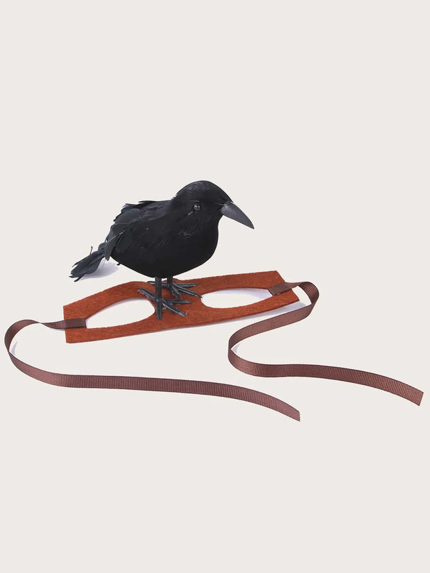 Black crow perched on a 1pc-Halloween Crow themed Pet Headwear with a brown strap on a light beige background
