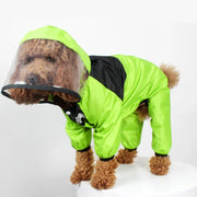 Dog wearing a bright green Dog Raincoat with Clear Hood on a white background